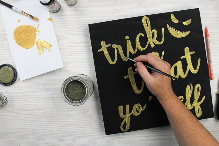 adding glitter paint to a halloween sign