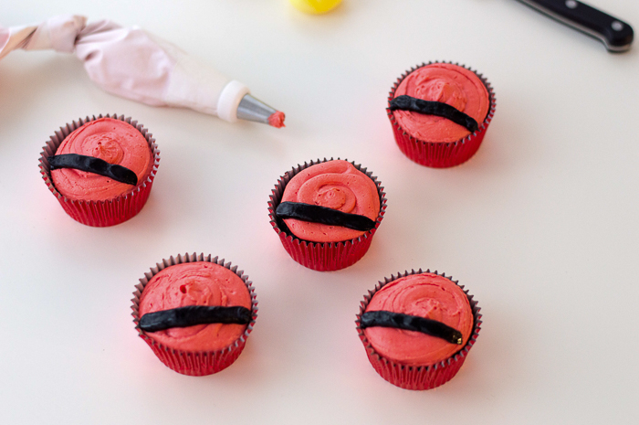 Start of Santa belt decoration on Christmas cupcakes.