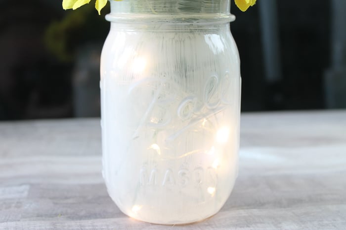 painted mason jar with lit up fairy lights inside