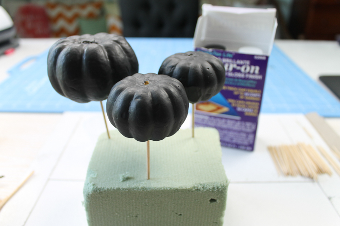 Adding pumpkins to a foam block for marbling.