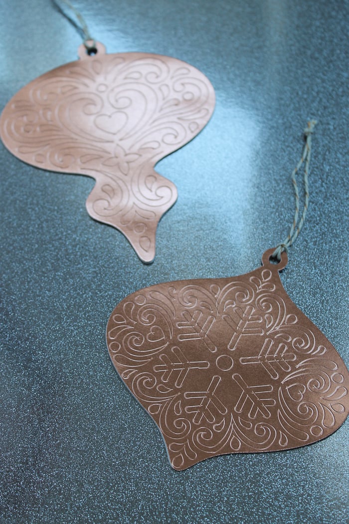 scored paper ornaments on surface with twine 