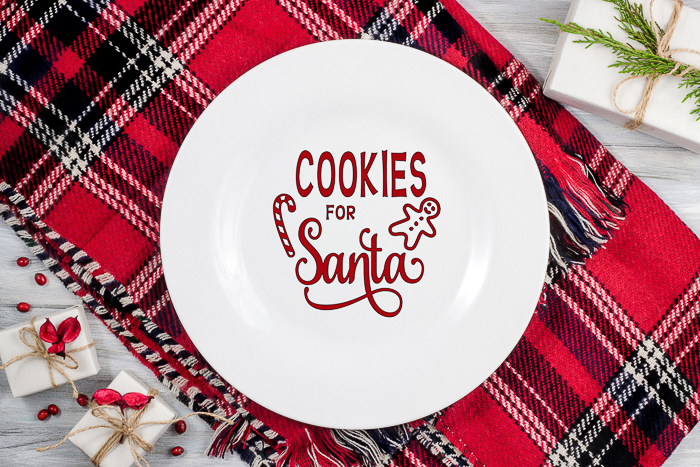 A close up of a plate on a table with cookies for santa svg