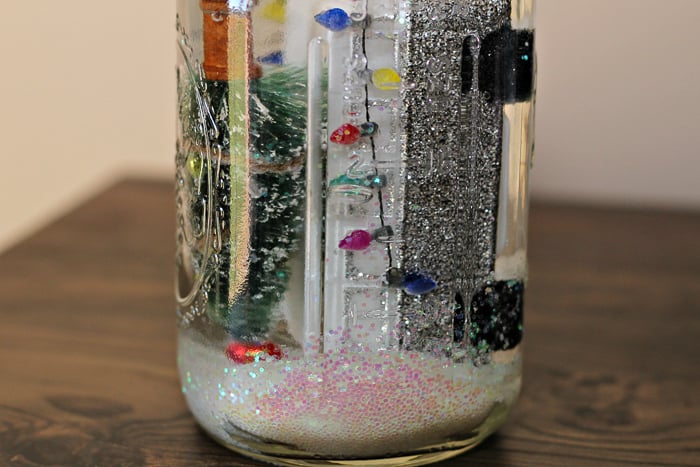 Snow Globe in a Jar adding water to a mason jar snow globe