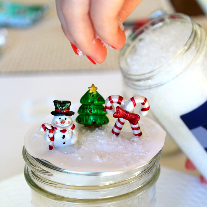 snow globe topper photo of adding glitter "snow" to the scene.