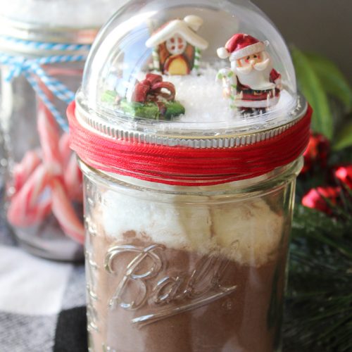 Make these mason jar Christmas gifts for those you love! Cute snow globe toppers for mason jars then add in hot chocolate or any other gift idea! #masonjars #christmas