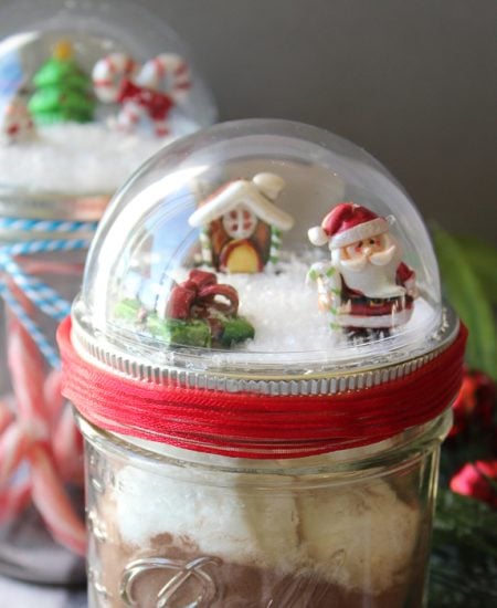 Make these mason jar Christmas gifts for those you love! Cute snow globe toppers for mason jars then add in hot chocolate or any other gift idea! #masonjars #christmas