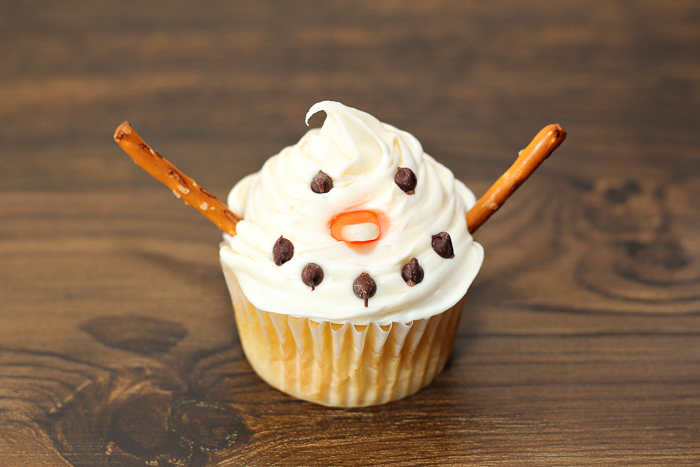 decorate a cupcake to look like a snowman