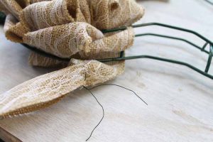 Attaching burlap to a heart wreath form.