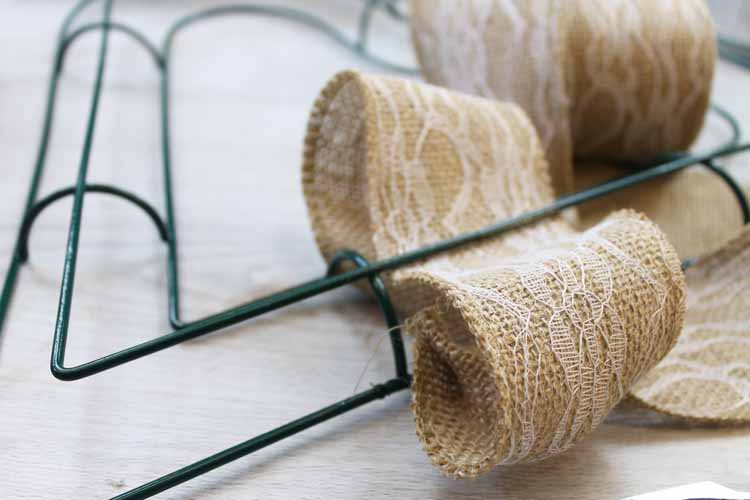 Adding burlap ribbon to a wire wreath form.