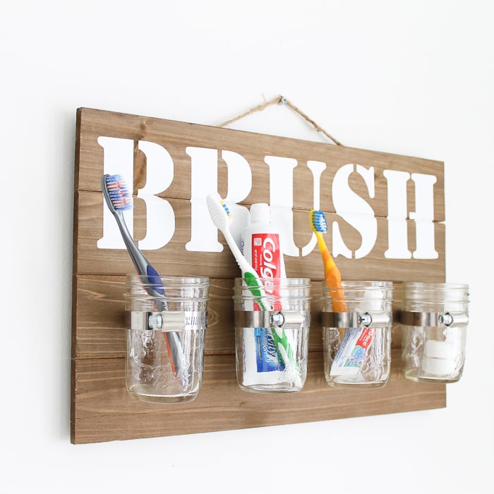 Make this mason jar wall decor! You can make you own bathroom organizer for your toothbrushes in minutes with this tutorial! #cricut #cricutmade #masonjar