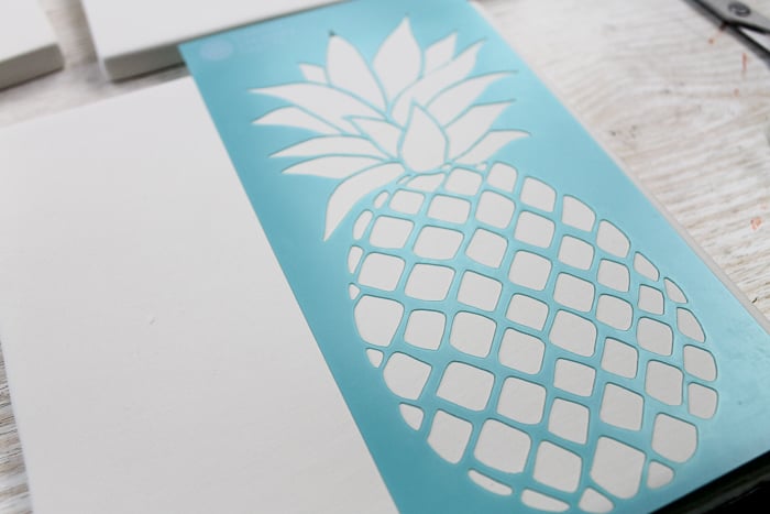 Using a stencil to paint on tile to make ceramic trivets.