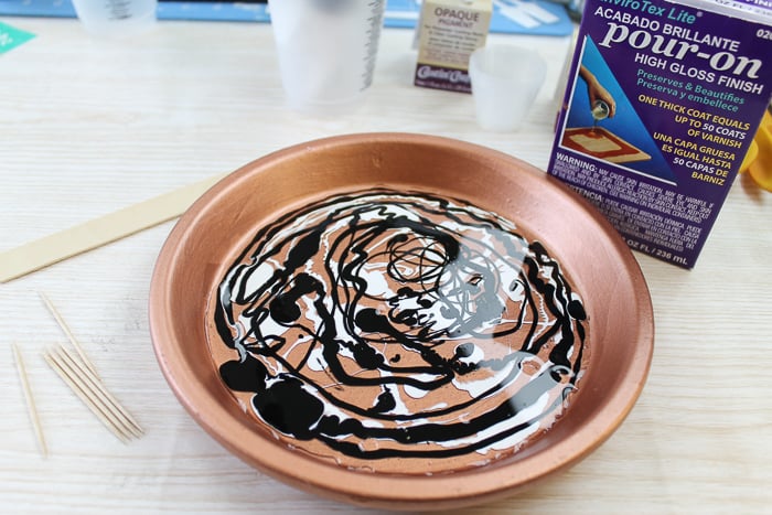 Marbling resin on top of a clay pot to make a cupcake stand.