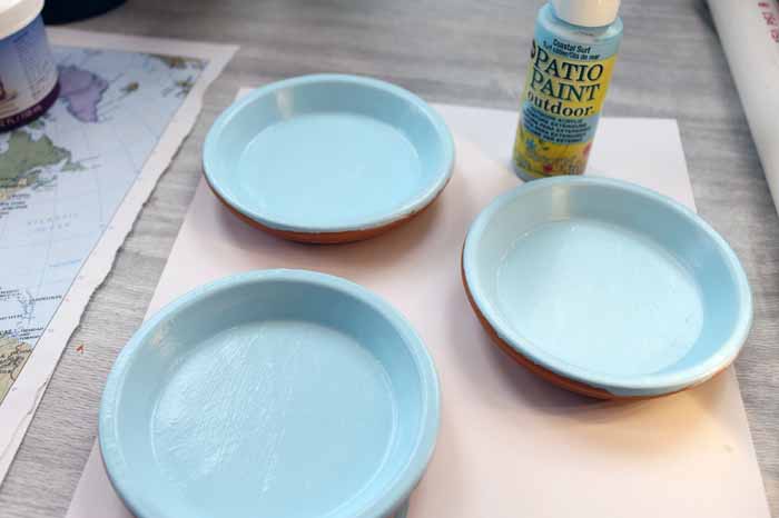 Adding outdoor paint to terra cotta saucers to make coasters.