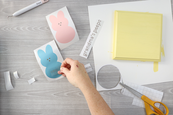 Using transfer tape to put together a grandma's peeps sign cut with the Cricut machine.