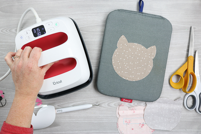 Ironing fabric with the Cricut EasyPress for a zipper pouch tutorial.