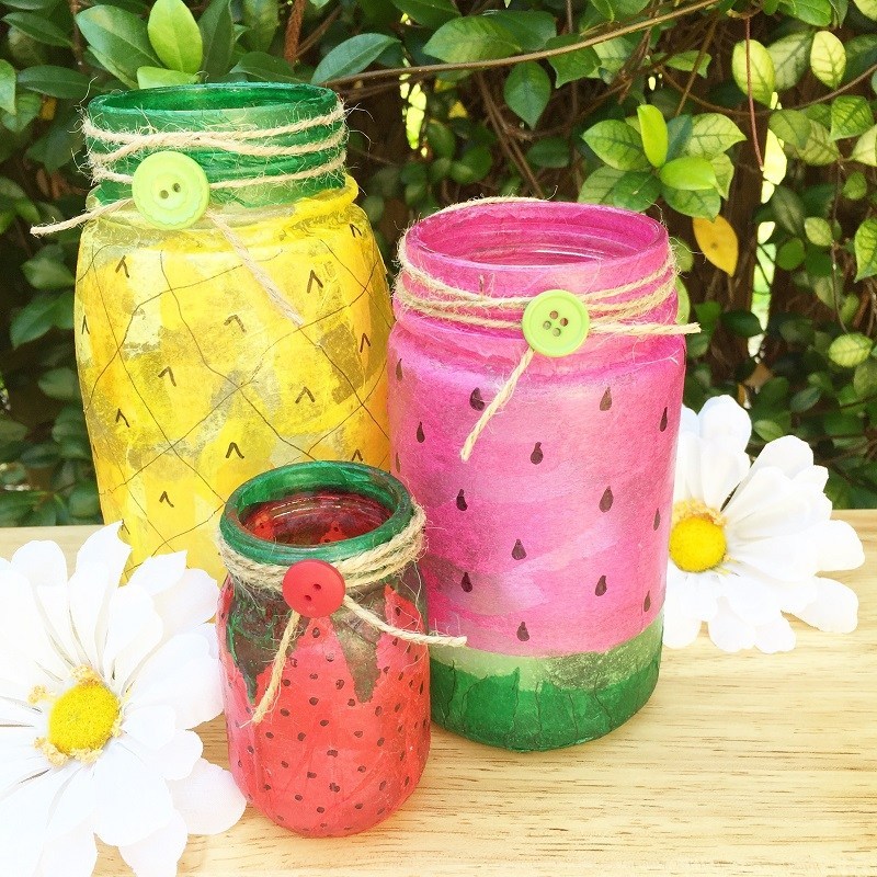A group of painted mason jars sitting on top of a table