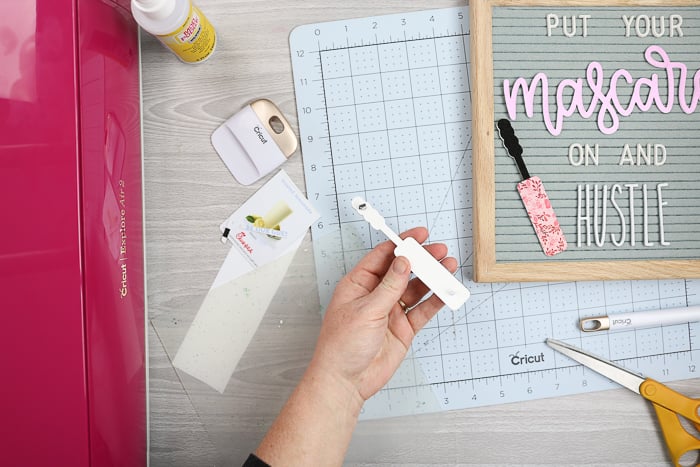 Adding the tabs to DIY felt letter board accessories using hot glue.