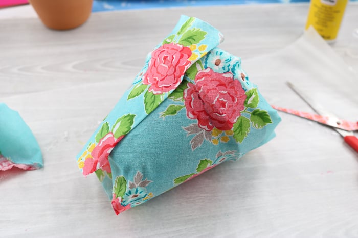 Cover the terracotta planter completely with the Mod Podge soaked fabric