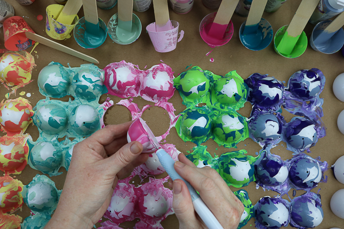 Cutting excess paint from a marbled Easter egg.