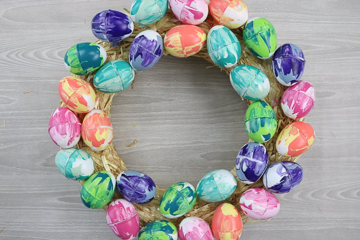 A wreath form covered in marble painted Easter eggs.