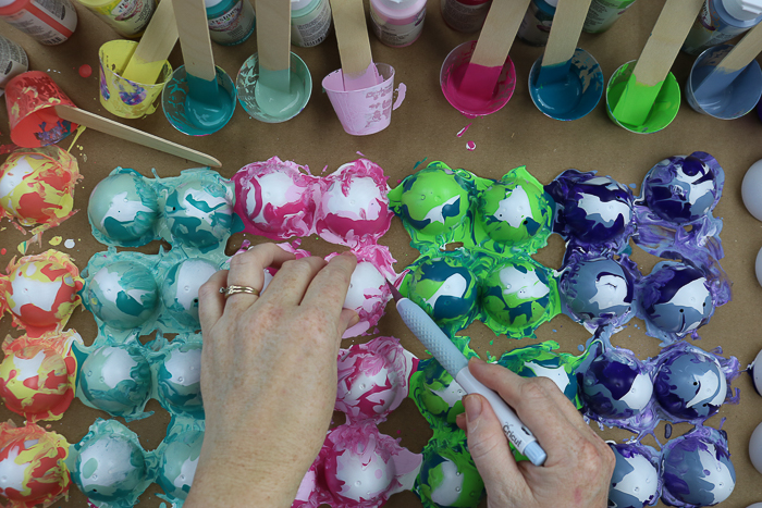 Removing paint poured eggs from cardboard.