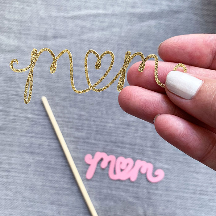 the word mom cut from gold glitter cardstock