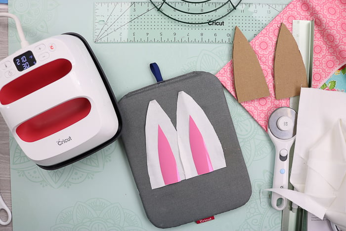 Adding middles to bunny ears using a Cricut EasyPress.