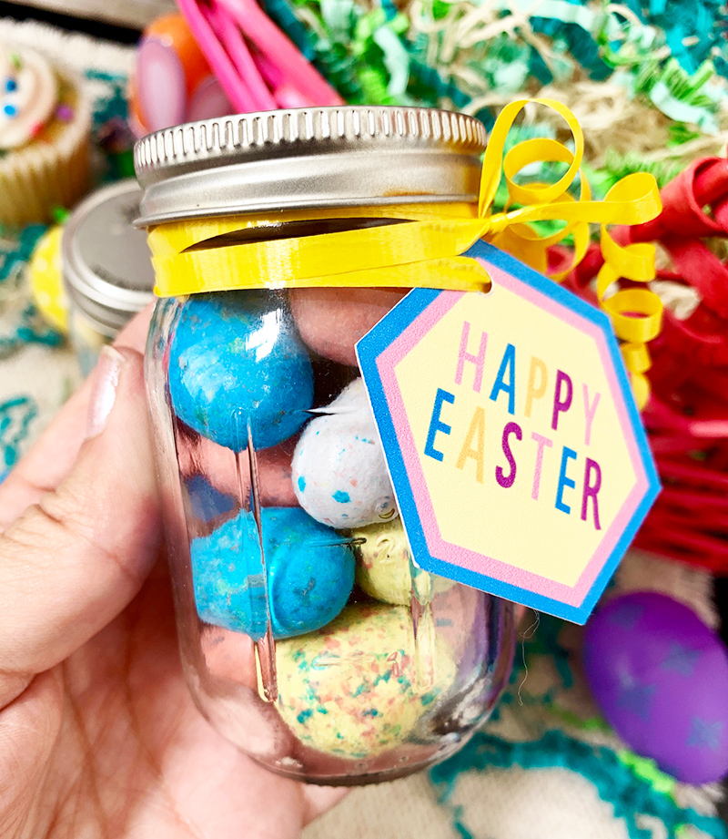 Adding a Happy Easter tag to a mason jar with yellow curling ribbon.