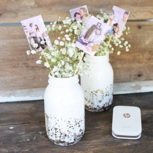 Wedding centerpieces with pictures of bride and groom in a mason jar.