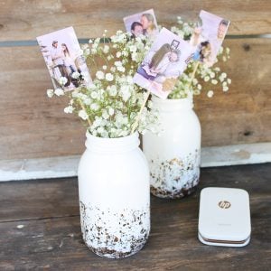 Centres de table de mariage avec des photos de jeunes mariés dans un pot Mason.