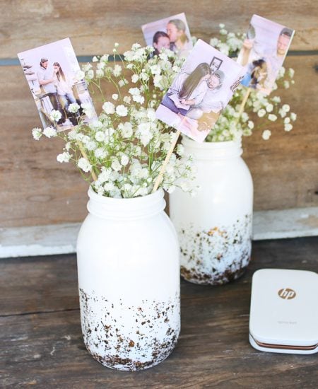 Wedding centerpieces with pictures of bride and groom in a mason jar.