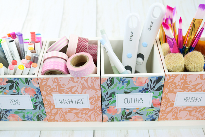 craft supply organizer filled with pens, washi tape, cutters, and brushes