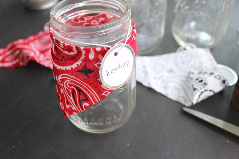 Adding a bandanna and a tag to mason jars for condiments at a bbq party