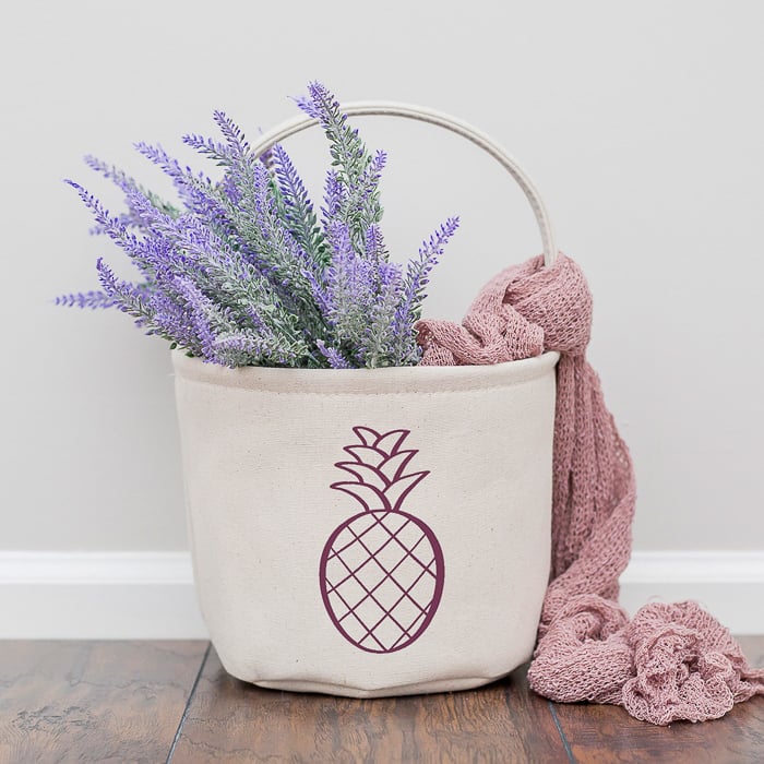 free pineapple SVG file used on a canvas basket with flowers and a blanket.