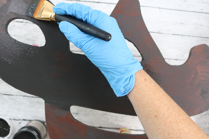 wearing gloves to apply second coat of rust effect paint