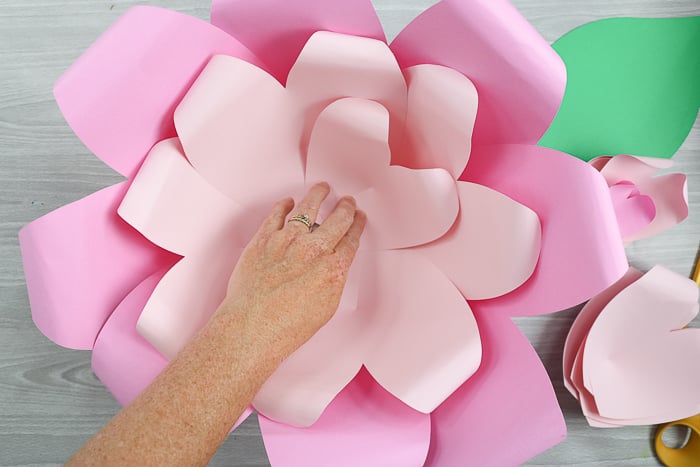 Begin layering the second layer of flower petals, using the smaller paper flower petals