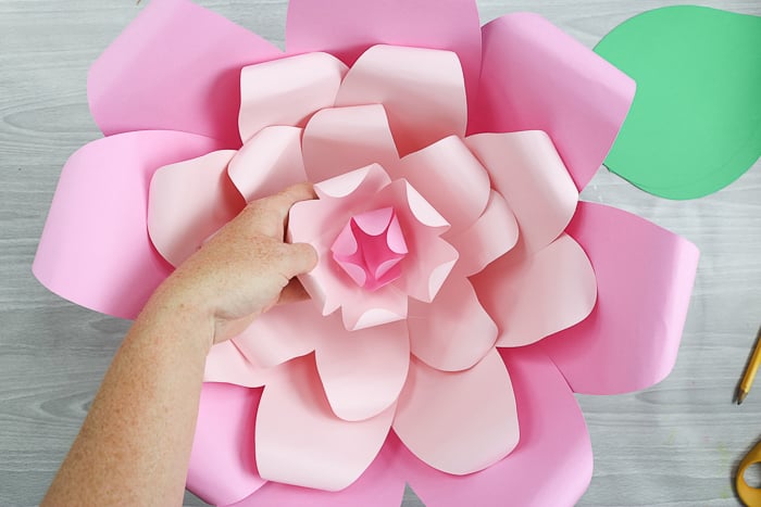 Add the center piece to the large paper flower using hot glue