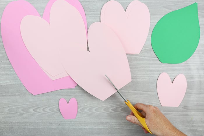 To create the petals for your giant paper flowers, cut paper into the shape of a heart, with the bottom pint cut off.