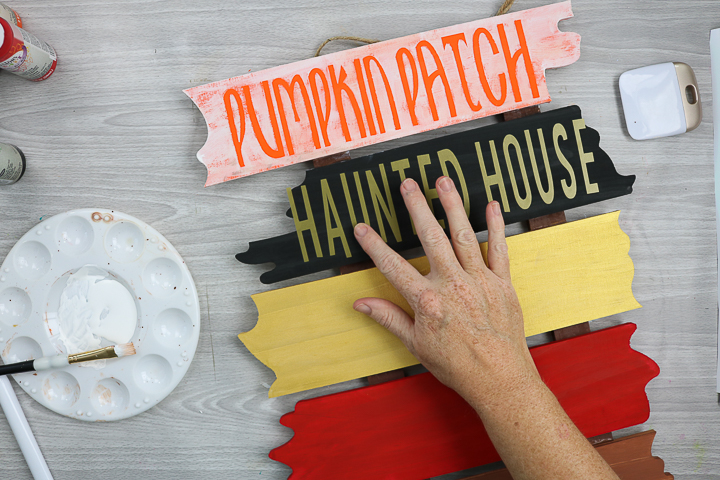 applying cricut vinyl to sign for halloween