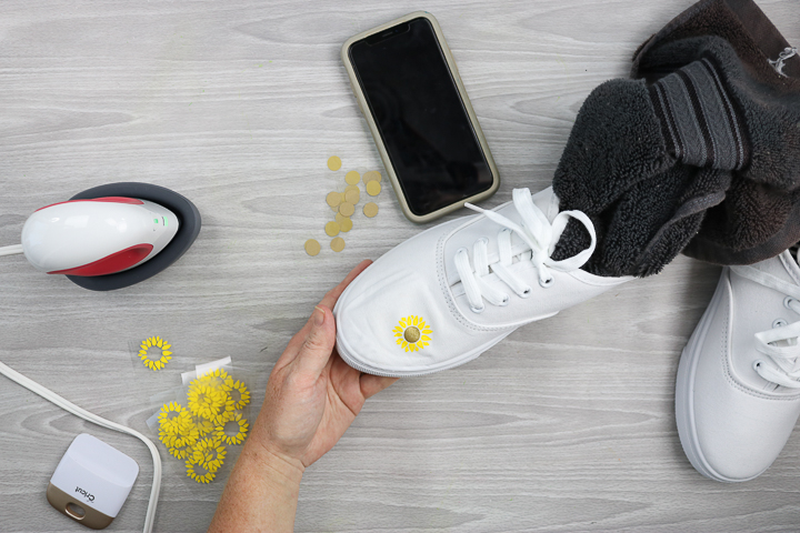 putting decorative flowers on shoes