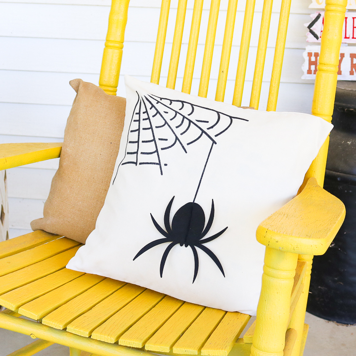 spider pillow for halloween in a yellow rocker
