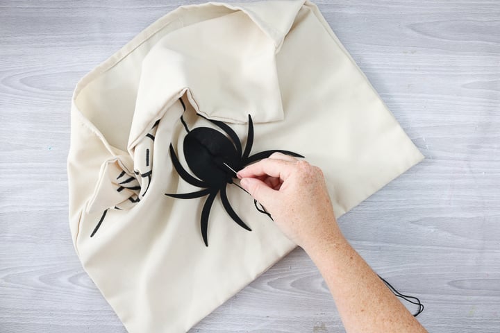 adding felt spider to DIY halloween pillow