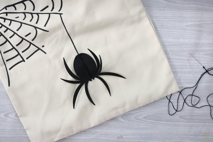 felt spider cut on cricut on a halloween pillow