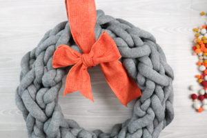 adding bow to yarn wreath