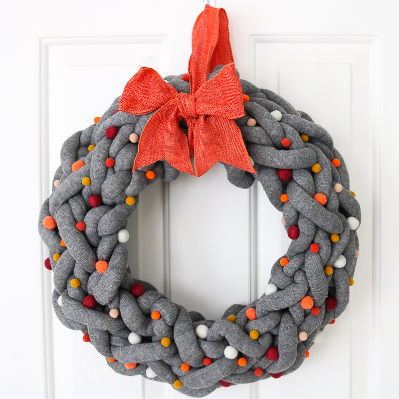 How to make a DIY fall wreath to hang on front door with orange bow and pom poms