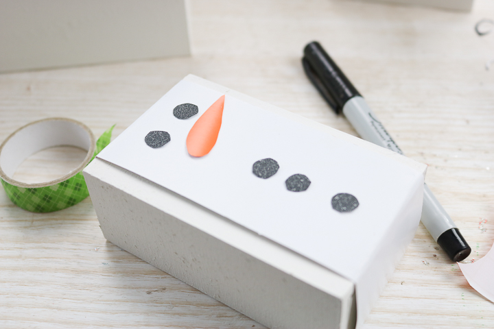 adding snowman details to a gift box