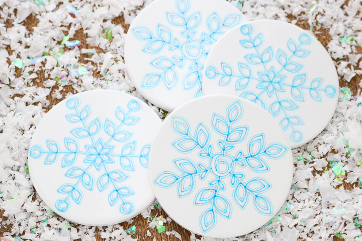four ceramic coasters with snowflake design