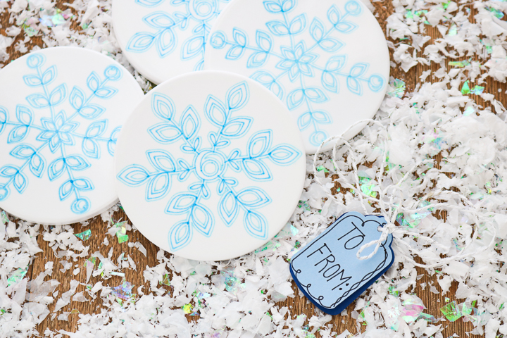 four ceramic coasters with snowflake design with gift tag