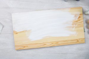 adding white paint to a board