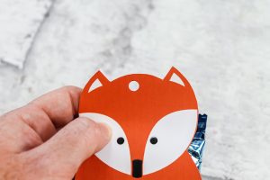 punching a hole in the top of a gift bag